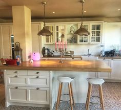 two stools sit at the center of a kitchen island