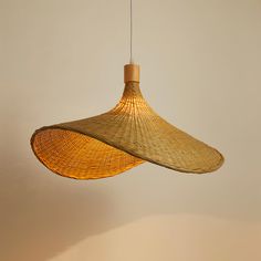 a bamboo lamp hanging from a ceiling in a living room or dining room with neutral walls and flooring