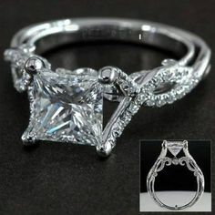 a princess cut diamond engagement ring with an intricate twist design on the band and side stones