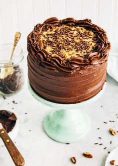 a chocolate cake sitting on top of a table next to other desserts and utensils