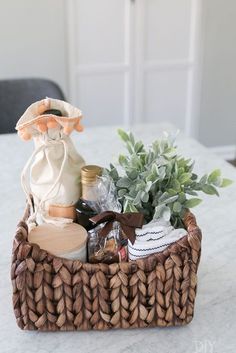 a wicker basket filled with items on top of a white marble table next to a potted plant