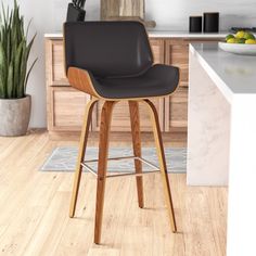 a black bar stool in a kitchen next to a potted plant