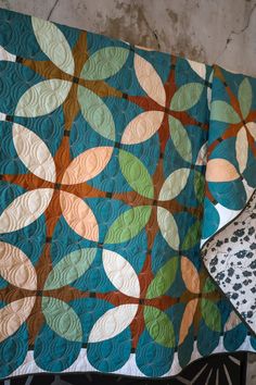 Retro Blossoms is a modern take on pieced curves with a nod to the past. This vintage floral inspired quilt has a mix and match-style color palette and three different kinds of traditionally pieced curves. Pattern includes 7 sizes: Pillow (20" x 20"), Wall Hanging (20" x 33"), Baby (47" x 47"), Table Runner (20" x 88"), Square Throw (61" x 61"), Large Throw (61” x 74") and Bed (88" x 88"). Click through to read more about the Retro Blossoms "Hemlock" quilt using Art Gallery Fabrics PURE Solids!