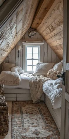 an attic bedroom with white bedding and wooden walls, along with a rug on the floor