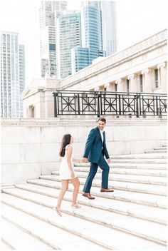 a man and woman walking up some steps