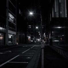 an empty city street at night with the lights turned on and no people in it