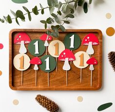 a wooden tray topped with cupcakes covered in mushrooms