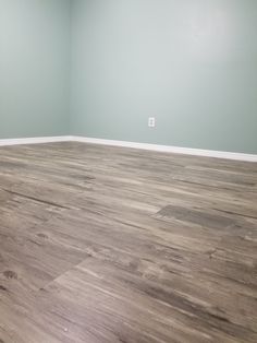 empty room with hard wood flooring and light blue paint on the walls in it