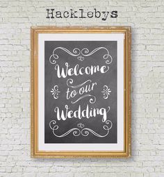 a chalkboard with the words welcome to our wedding written on it in front of a brick wall