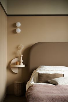 a bed sitting next to a wall mounted shelf