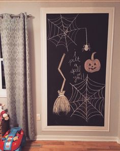 there is a chalkboard with halloween decorations on it in the corner of this room