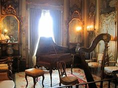 an old piano is sitting in the middle of a room with antique furniture and mirrors