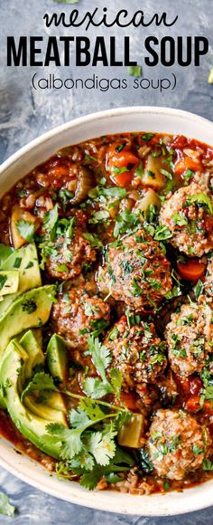 mexican meatball soup in a white bowl with avocado and cilantro