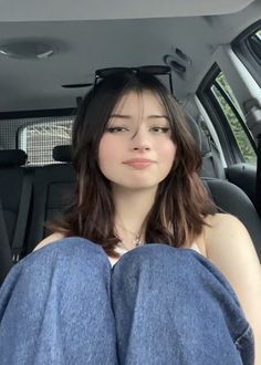 a woman sitting in the back seat of a car with her feet on the floor