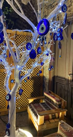 a blue and white tree with evil eyes on it's branches in front of a building