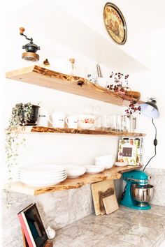 an instagram photo of a kitchen counter with plates and bowls on it's shelves