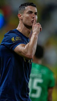 a soccer player holding his hand up to his mouth