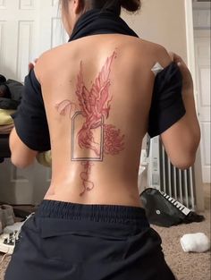 the back of a woman's body with tattoos on it