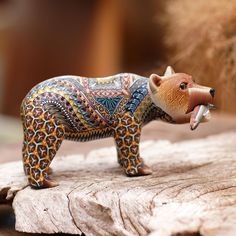 a figurine of a bear on top of a piece of wood with it's mouth open