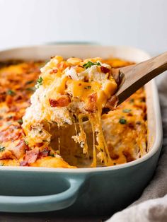 a casserole dish with cheese and bacon being lifted from the casserole