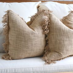 two burlap pillows on a white couch