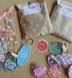 several personalized key chains and tags are on the table next to some paper bags