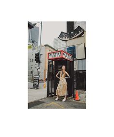 a woman standing in front of a phone booth