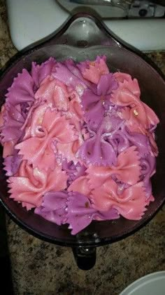 purple and pink flowers in a bowl on a counter