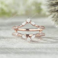 a rose gold wedding ring set with two pear shaped diamonds on the top and bottom