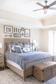 a bedroom with a bed, dressers and pictures on the wall above it's headboard