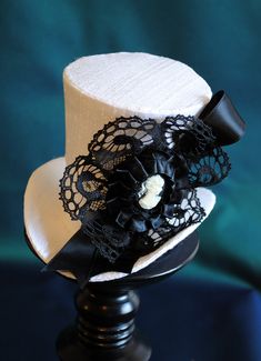 A bridal, victorian inspired mini top hat that is a simple yet elegant piece.This fascinator mini hat is covered with white silk shantung and adorned with black satin ribbon in a vertical half bow, vintage black cotton lace in a rosette, pleated satin ribbon, which forms an oval frame for a beautiful black and white victorian profile cameo. Choose between with or without black veil. Also available in black: https://www.etsy.com/bizarrenoir/listing/167213458/ More color options: https://www.etsy. Bridal Mini, White Wedding Decor, Dark Green Top, White Gothic, Hat Aesthetic, White Victorian, Mini Top Hat, Fascinator Hat, Mini Top