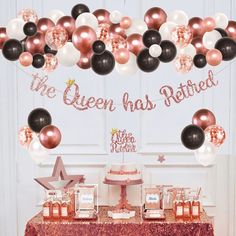 a table topped with lots of balloons next to a red and white table cloth covered in confetti