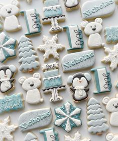 cookies decorated with blue and white frosting are arranged on a table