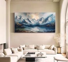 a living room filled with furniture and a large painting on the wall above it's windows