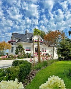 a large white house sitting on top of a lush green field