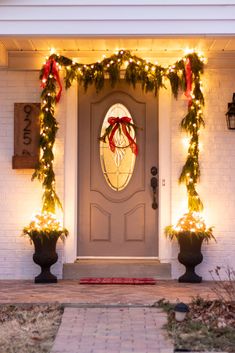 the front door is decorated for christmas with garland and lights