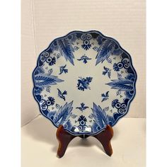 a blue and white plate on a wooden stand