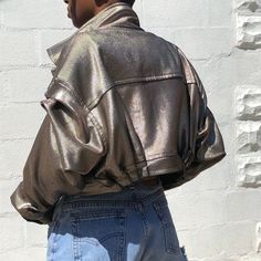 James Dean Inspired crop bicker jacket with a futuristic modern metallic fabric. This piece is 1 of 1, other sizes must be ordered -Metallic Painted Corded Fabric -2 front patch pockets -Lapel notch collar -Pleated sleeve and waist -Epaulette cuff -Dry clean only (can be hand washed gently) -Steam only (no Hot iron) Futuristic Fall Outerwear With Pockets, Trendy Metallic Outerwear For Fall, Chic Metallic Outerwear For Night Out, Trendy Fitted Metallic Outerwear, Metallic Fitted Long Sleeve Outerwear, Metallic Outerwear With Pockets For Fall, Trendy Metallic Fitted Outerwear, Metallic Fitted Outerwear In Trendy Style, Chic Fitted Metallic Outerwear