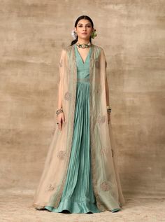 This set features a teal rushed full-length silk anarkali paired with champagne gold organza embroidered cape. Fabric: Silk; Organza Color: Teal; Champagne; Blush Pink Care: Dry Clean Only Luxury Organza Anarkali Set With Ruffles, Luxury Organza Anarkali Set Maxi Length, Luxury Chanderi Maxi Length Gown, Luxury Organza Anarkali Set For Ceremonies, Luxury Organza Anarkali Set, Luxury Organza Maxi Anarkali Set, Luxury Organza Ruffled Anarkali Set, Luxury Fitted Organza Anarkali Set, Luxury Ruffled Organza Anarkali Set