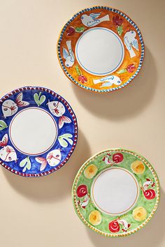 three plates with designs on them sitting next to each other