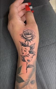 a woman's arm with a rose and two faces tattoo on the left forearm