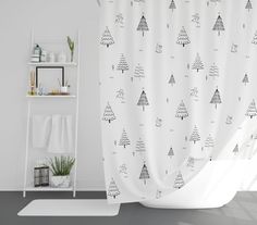 the shower curtain is decorated with christmas trees on white and gray colors, along with a rug in front of it