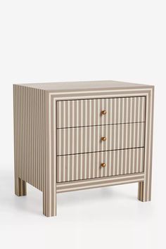 a white and brown striped chest of drawers with gold knobs on the bottom drawer