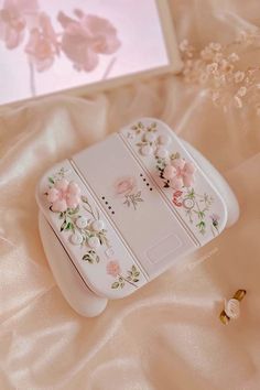 an electronic device with flowers on it sitting on a bed