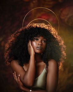 a woman with an afro is posing for a photo in front of a dark background