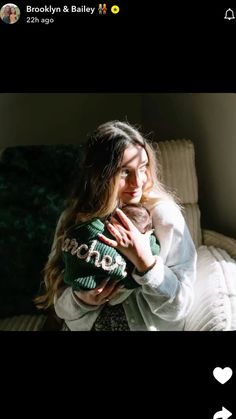 a woman holding a baby in her arms and looking at the camera with love on it