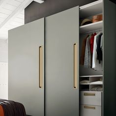 an open closet with clothes hanging on the wall and two doors opened to reveal another closet