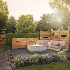 an outdoor living area with fire pit, seating and plants on the side of it