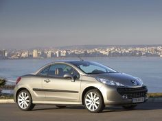 a silver car parked in front of a large body of water