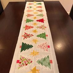 a table runner made out of quilts on top of a wooden table